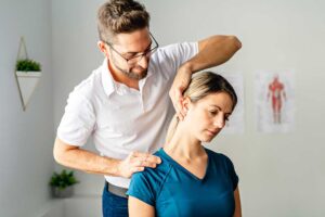 An adult and teenager viewing a spinal X-ray together in a medical office, discussing back health.
